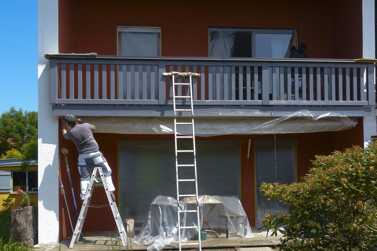 Painter on a ladder at a house